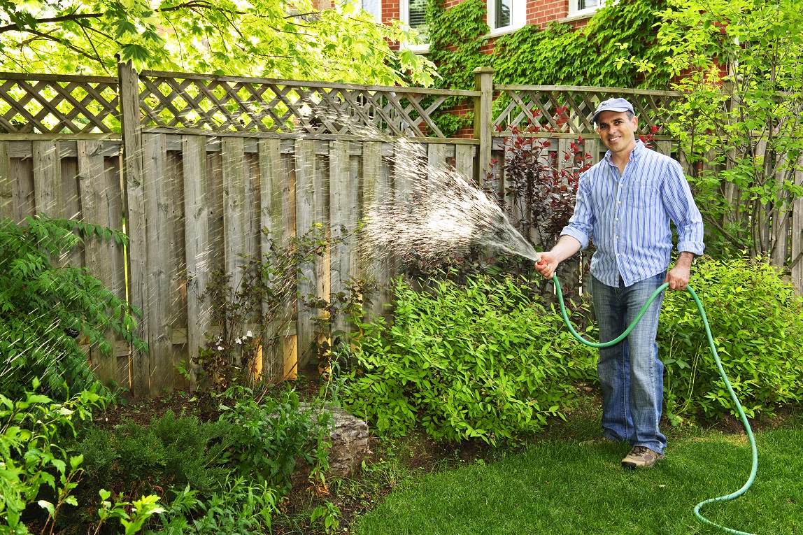 man watering garden and lawn