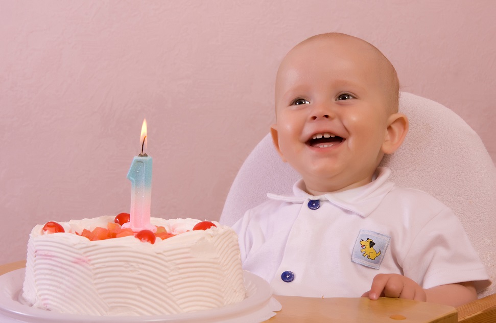 Adorable little boy on his first birthday with cake