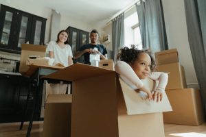 A couple watching their daughter inside a cardboard box
